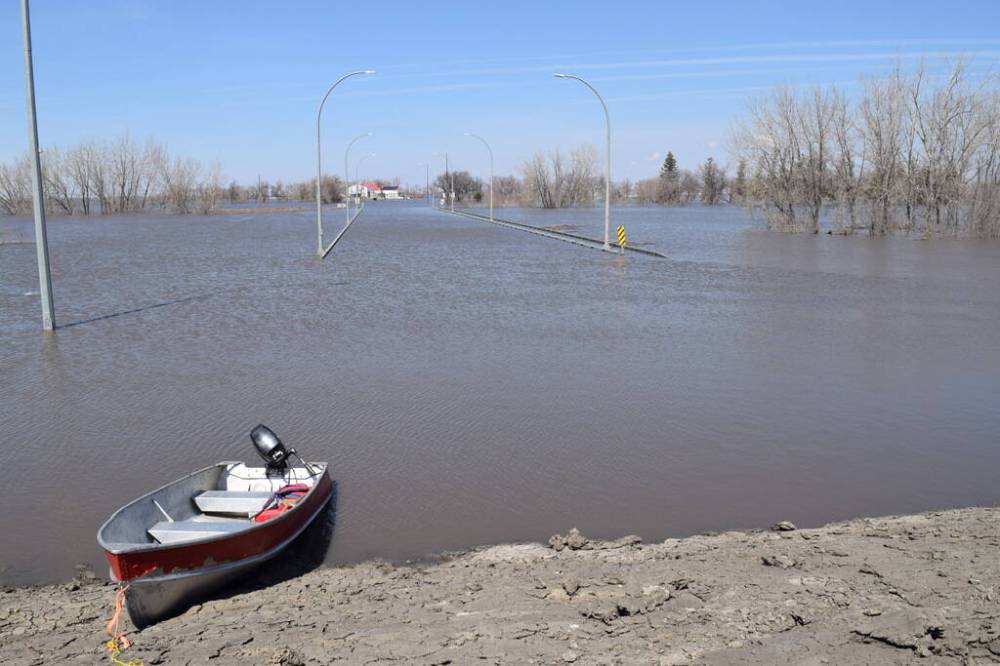 CHRIS KITCHING / WINNIPEG FREE PRESS FILES
Rural residents are using boats, including this one at the dike on the north side of Morris, to get to and from the town. The province issued an overland flood warning for parts of southwest and southeast Manitoba ahead of the rainstorm.