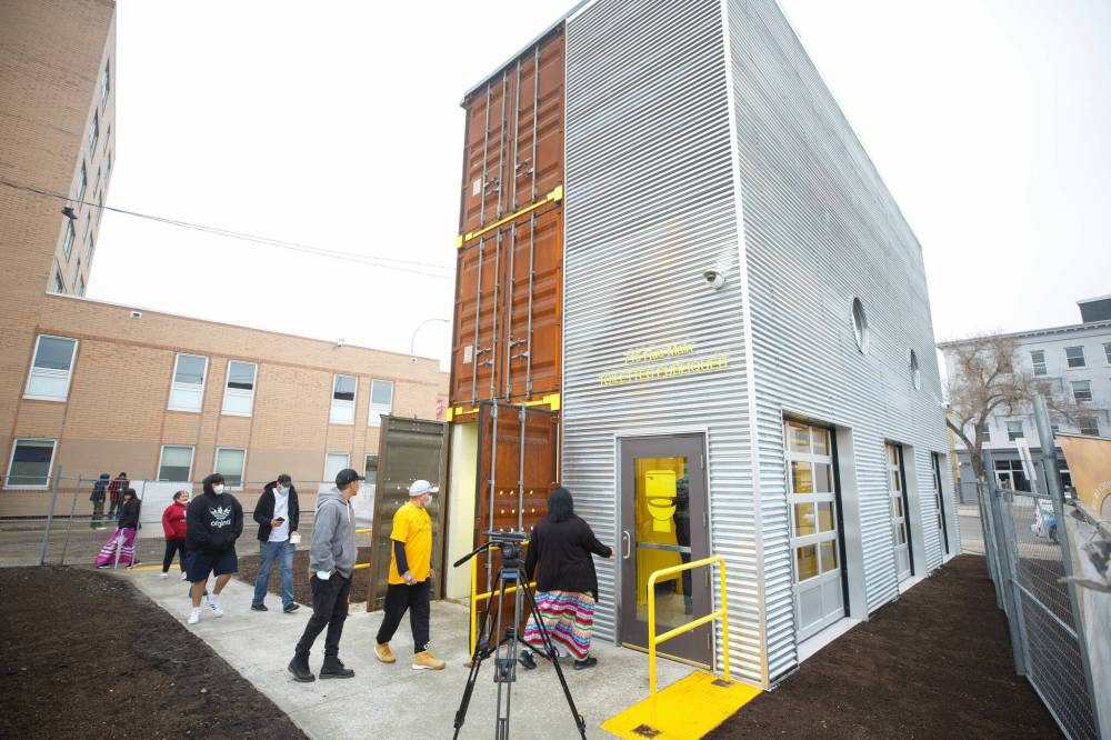 The three-storey public washroom has a blend of metal, glass and shipping container materials with bright yellow accents. It has three large glass garage-style doors that provide an open look for the public sink area, which also includes a drinking water fountain and foot-washing station. (Mike Deal / Winnipeg Free Press)