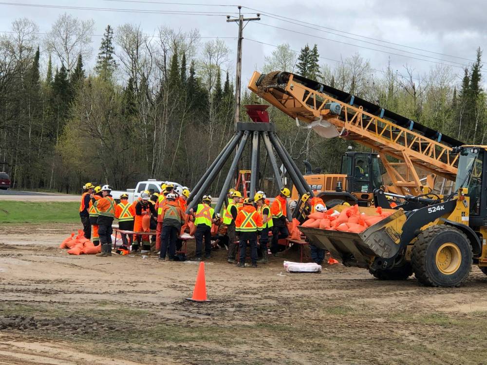 Ben Kahler / Winnipeg Free Press
Manitoba Parks employees fill sandbags at Otter Falls in Whiteshell Provincial Park Wednesday. The area is experiencing widespread flooding from the swollen Winnipeg River which has spilled over its banks flooding roads and private residences throughout the park.