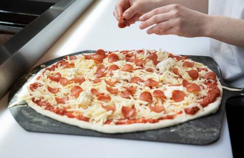 JESSICA LEE / WINNIPEG FREE PRESS
Parcel Pizza chef Jessica Champion-Taylor adds pepperoni on a pizza.