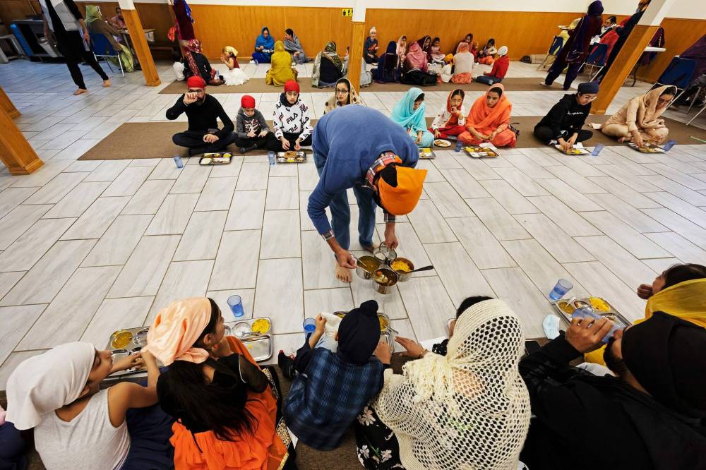 PRABHJOT SINGH / WINNIPEG FREE PRESS
At langar, food is served to devotees while they sit on the floor in a line, signifying the importance of equality.