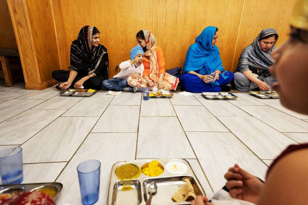 PRABHJOT SINGH / WINNIPEG FREE PRESS
Women chat while waiting for food to be served at Gurdwara Singh Sahab Sunday langar.