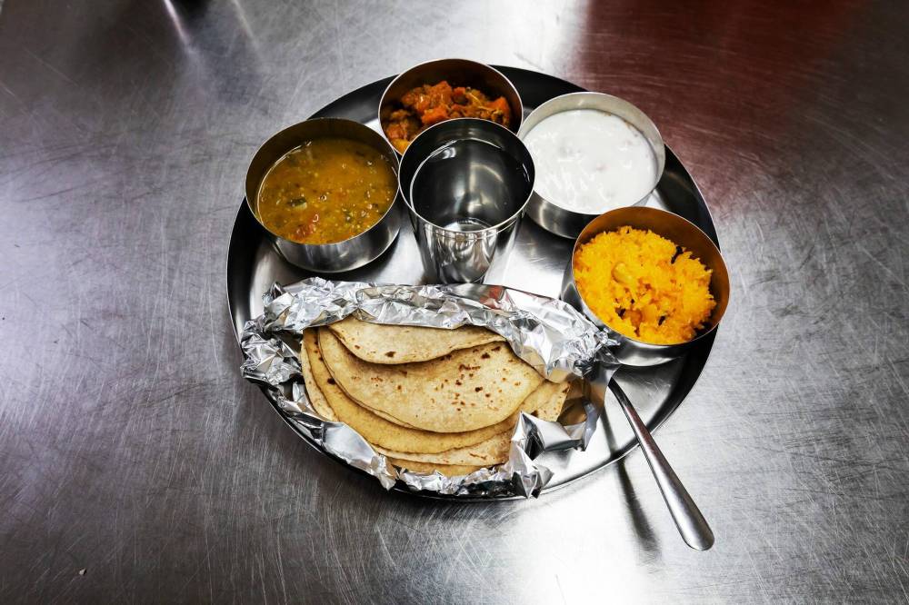 PRABHJOT SINGH / WINNIPEG FREE PRESS
Food at langar is first offered to the Guru Granth Sahib for blessing; a small portion of everything is put into one plate.