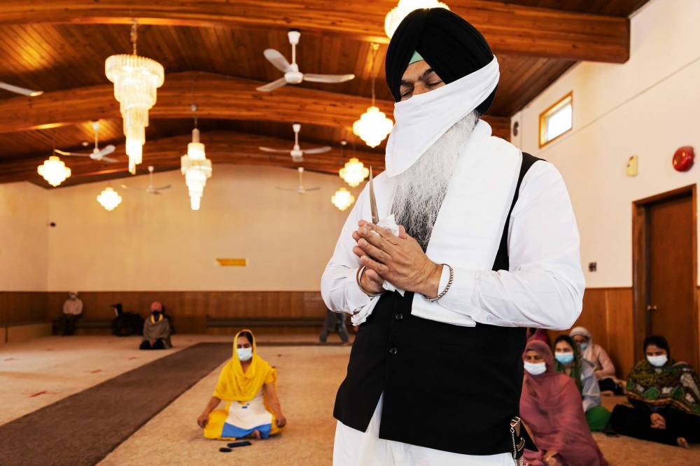 PRABHJOT SINGH / WINNIPEG FREE PRESS
Bikram Singh prays with a Kirpan (sacred dagger), which will then be swiped across the food.
