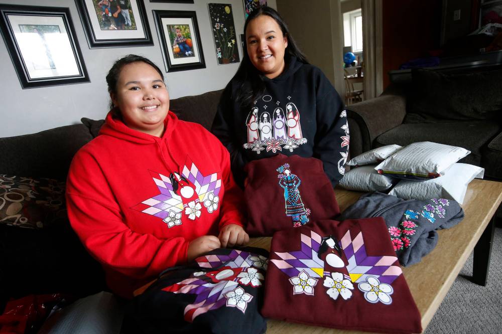 JOHN WOODS / WINNIPEG FREE PRESS FILES
Ariel Spence, left, and her mother Crissy Slater, owners of Red Road Clothing pack some of their clothing orders in their home.