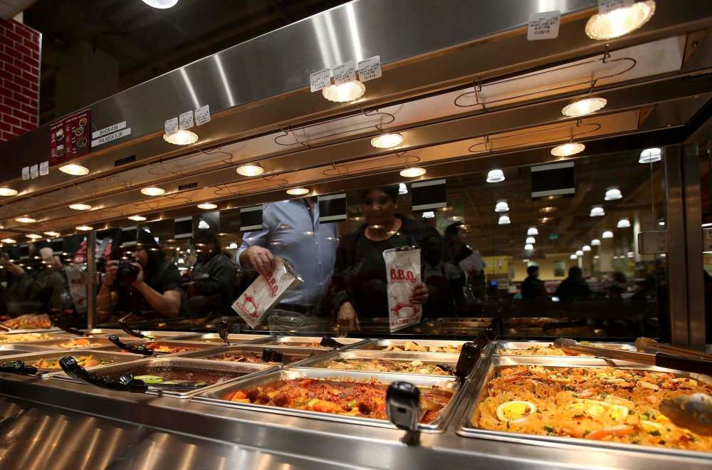 SHANNON VANRAES / WINNIPEG FREE PRESS
Staff prepare Tuesday for Thursday’s grand opening of Seafood City at Garden City Shopping Centre in Winnipeg. The supermarket includes multiple fast-food counters that offer eat-in and takeout options.