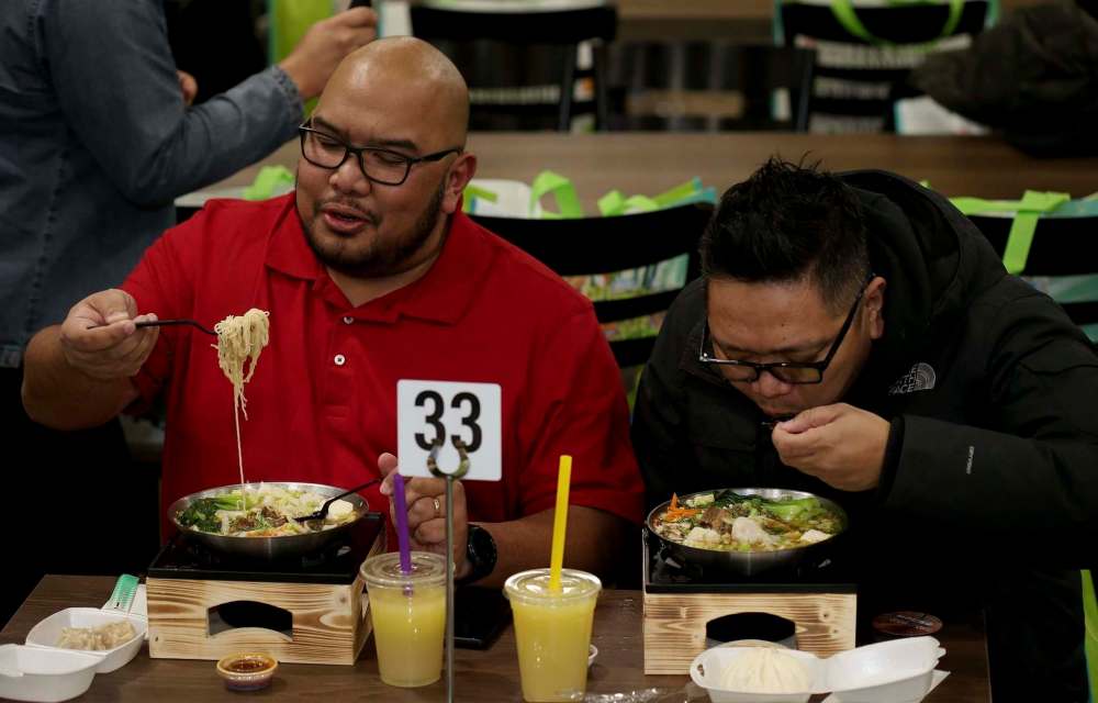 SHANNON VANRAES / WINNIPEG FREE PRESS
JP Sumbillo and Henry Balanial sample the fare at Noodle Street, a restaurant offering Filiipino-Chinese fusion dishes.