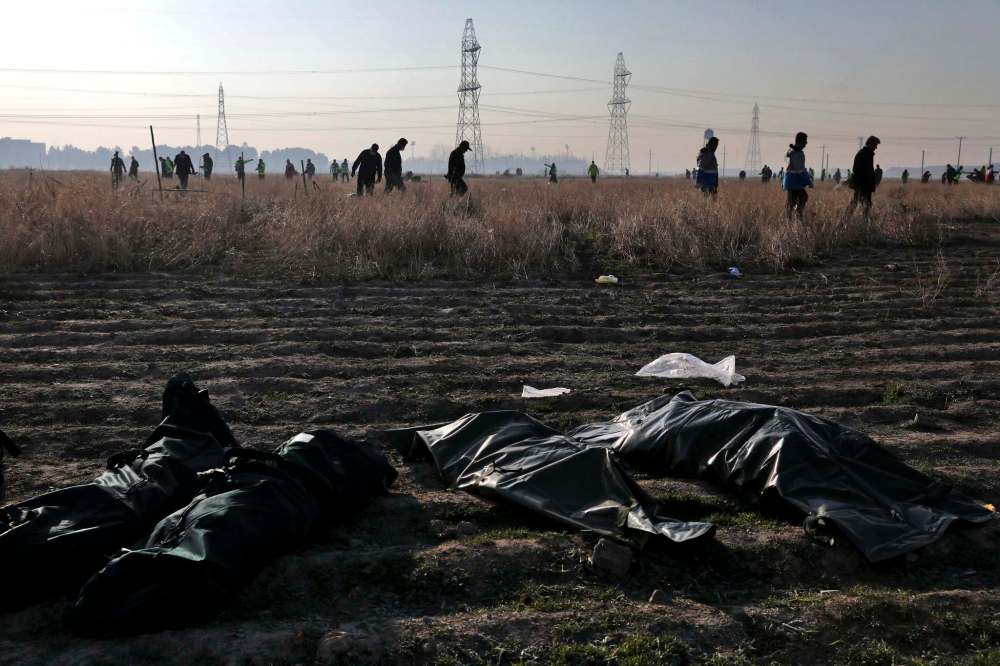 (AP Photo/Ebrahim Noroozi)
Rescue workers search the scene where a Ukrainian plane crashed as the bodies of victims in body bags lie on the ground, in Shahedshahr, southwest of the capital Tehran, Iran, Wednesday. A Ukrainian airplane with more than 170 people crashed on Wednesday shortly after takeoff from Tehran's main airport, killing all onboard.