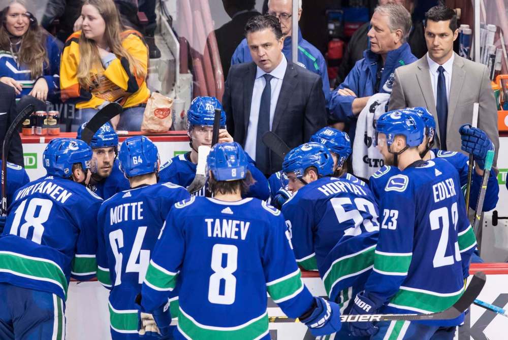 Vancouver Canucks head coach Travis Green, back centre, and assistant coach Nolan Baumgartner, back right, stand on the bench during third period NHL hockey action against the Nashville Predators, in Vancouver on Thursday, Dec. 6, 2018. THE CANADIAN PRESS/Darryl Dyck