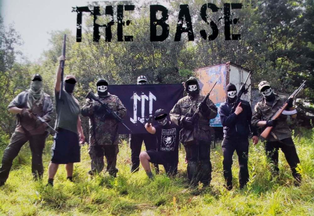 From court documents: Brian Lemley is standing second from the left while holding a long gun straight in the air, and William Bilbrough is kneeling in the centre under The Base flag while holding a blade. (U.S Attorney Detention Motion)