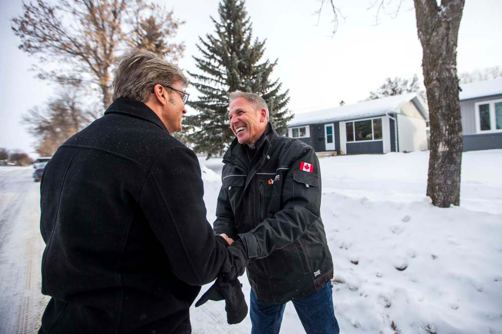 Coun. Kevin Klein (left) checks out Chuck Lewis's work on Thursday. (Mikaela MacKenzie / Winnipeg Free Press)