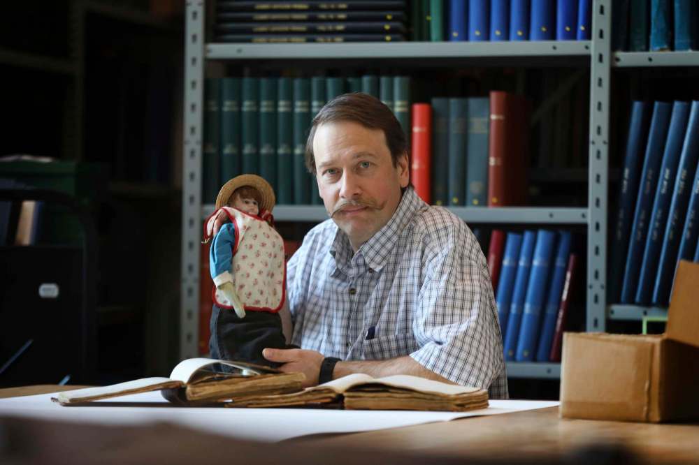 Conrad Stoesz with a doll that was used to smuggle money out of Russia in the 1920s.
