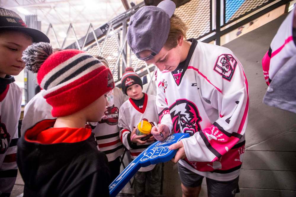Karter Prosofsky signs autographs for Selkirk Fishermen junior hockey players after winning 4-1 against the Medicine Hat Tigers on Feb. 8.