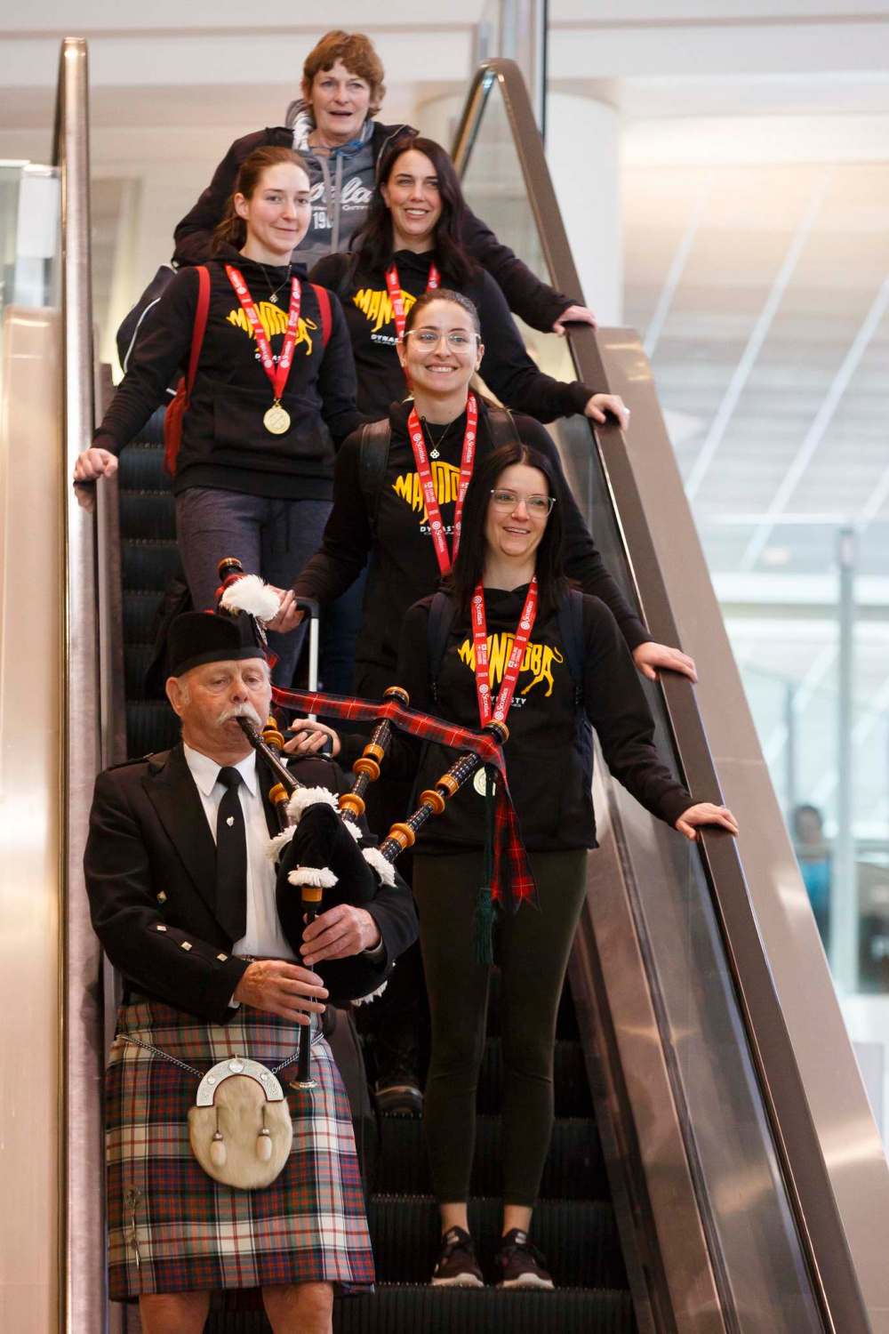 MIKE DEAL / WINNIPEG FREE PRESS
Members of Team Manitoba lead by skip Kerri Einarson (foreground), Shannon Birchard (middle), Briane Meilleur (back left) and Jennifer Clark-Rouire (back right), are piped in on their arrival back home Monday morning.
