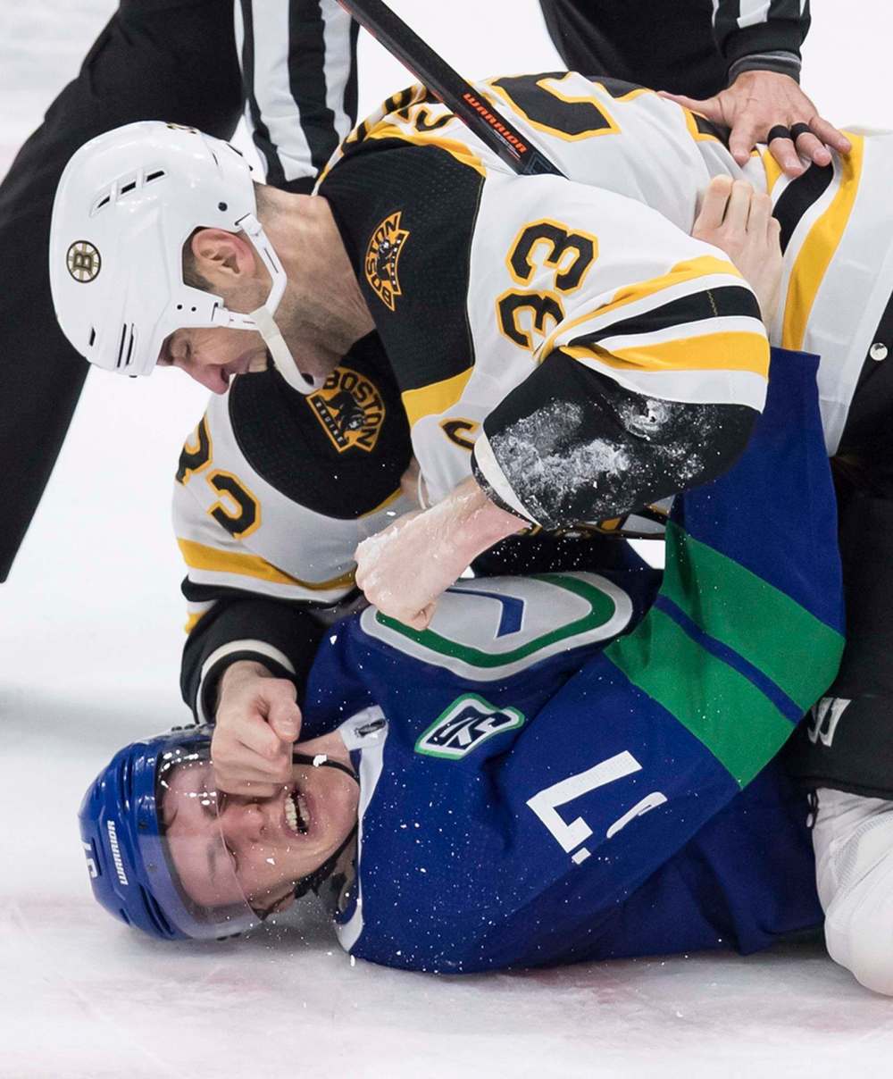 Boston's Zdeno Chara punches Vancouver's Tyler Myers on Saturday. Chara won the fight, but Vancouver won the game 9-3. (Darryl Dyck / The Canadian Press files)