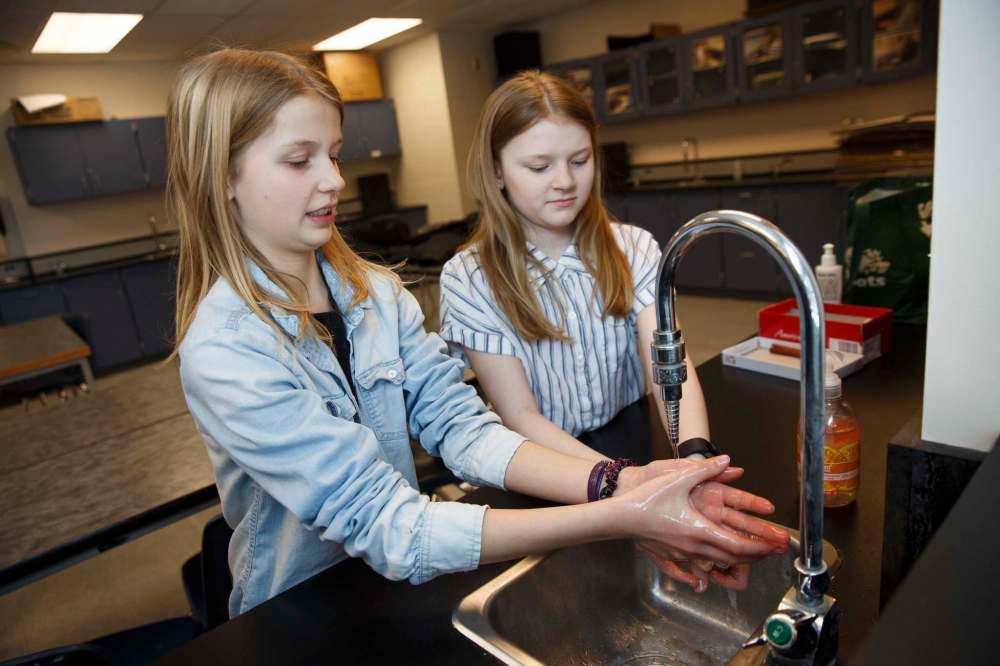 Sadie Wiebe, 12, (left) and Jillian Everton, 12, show off the proper way to wash hands, something we all should follow. (Mike Deal / Winnipeg Free Press)