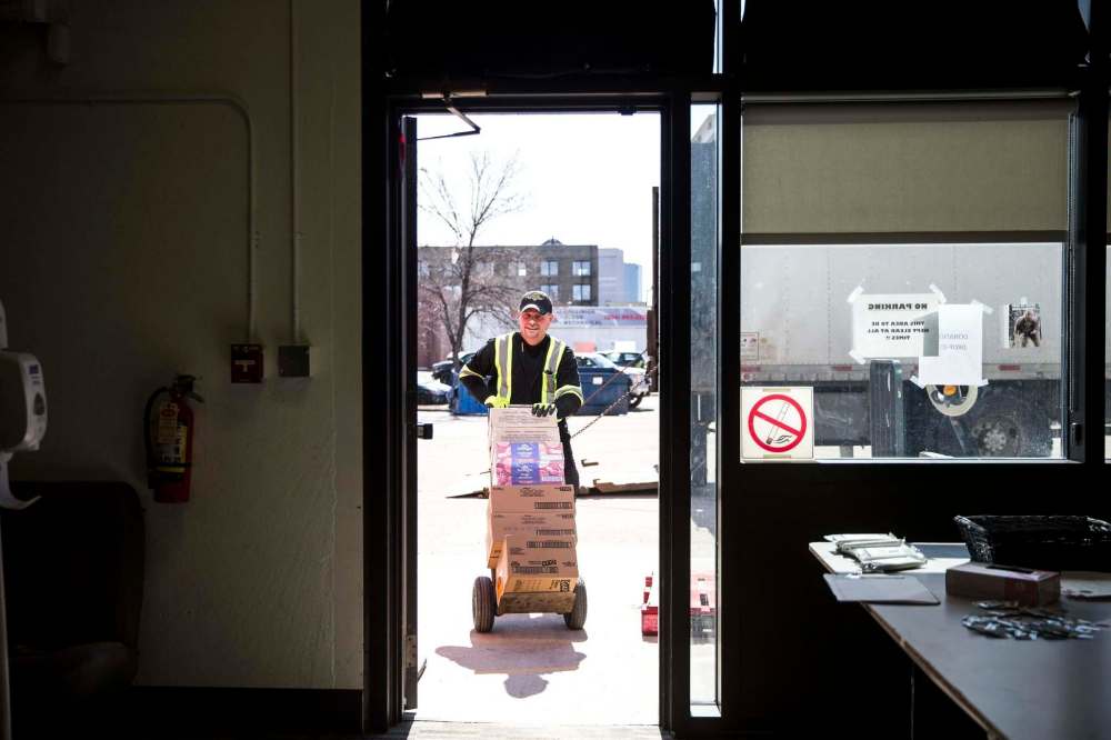 Peter Borys brings a food delivery in before volunteers begin putting together emergency kits. (Mikaela MacKenzie / Winnipeg Free Press)