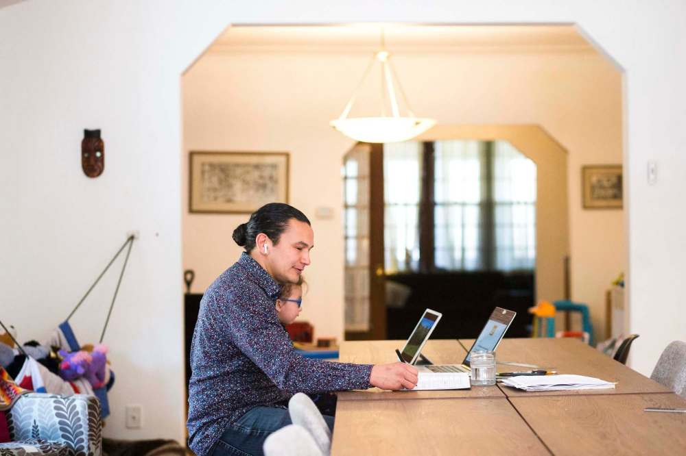 MIKAELA MACKENZIE / WINNIPEG FREE PRESS 
Wab Kinew works from home with his one-year-old, Tobasonakwut Kinew, on his lap.