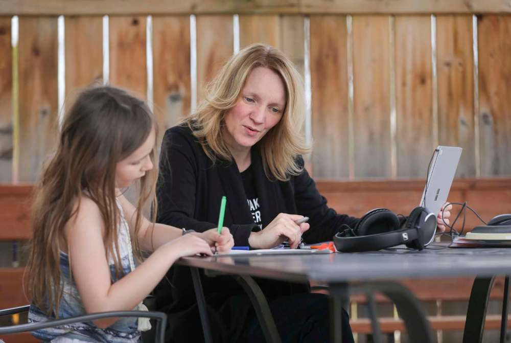Teacher Cori Wiebe, with her daughter, Eva, 8, misses the social contact with students, but is finding online teaching is getting easier. (Ruth Bonneville / Winnipeg Free Press)