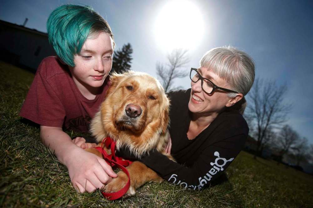 JOHN WOODS / WINNIPEG FREE PRESS
Sunny Szpak-Holly and her child, Devon, play with their newly adopted dog, Mindy, an 18-month-old golden retriever/great Pyrenees.