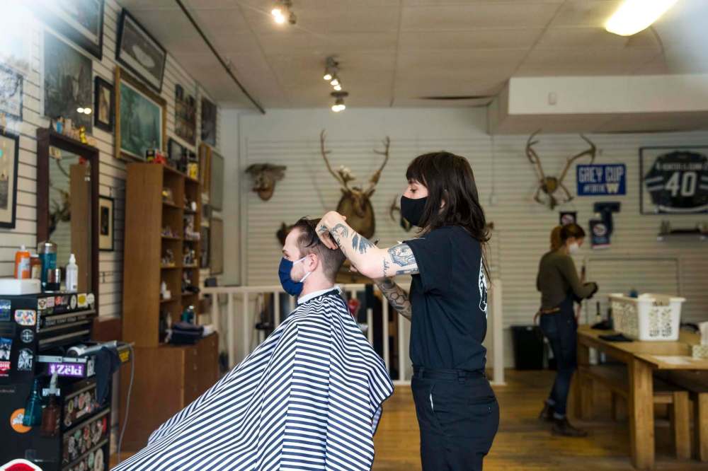 MIKAELA MACKENZIE / WINNIPEG FREE PRESS
Caitlin Bousfield cuts Ryley Daly's hair at Hunter & Gunn.