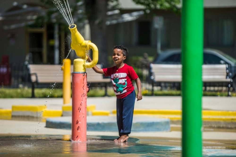 MIKAELA MACKENZIE / WINNIPEG FREE PRESS
Equinan Geberslasie plays at the splash pad at Central Park on the first day of re-opening in Winnipeg on Wednesday.