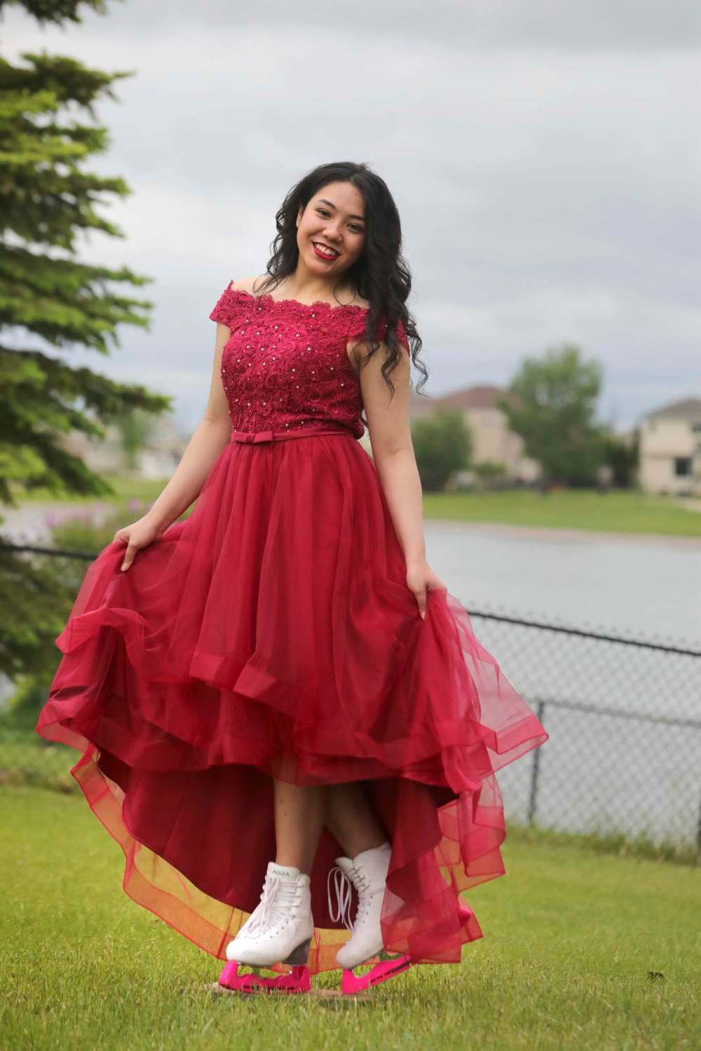 Vanessa Navarro, who danced and did figure skating throughout her formative years, poses in her grad dress with her skates in the family’s yard. (Ruth Bonneville / Winnipeg Free Press)