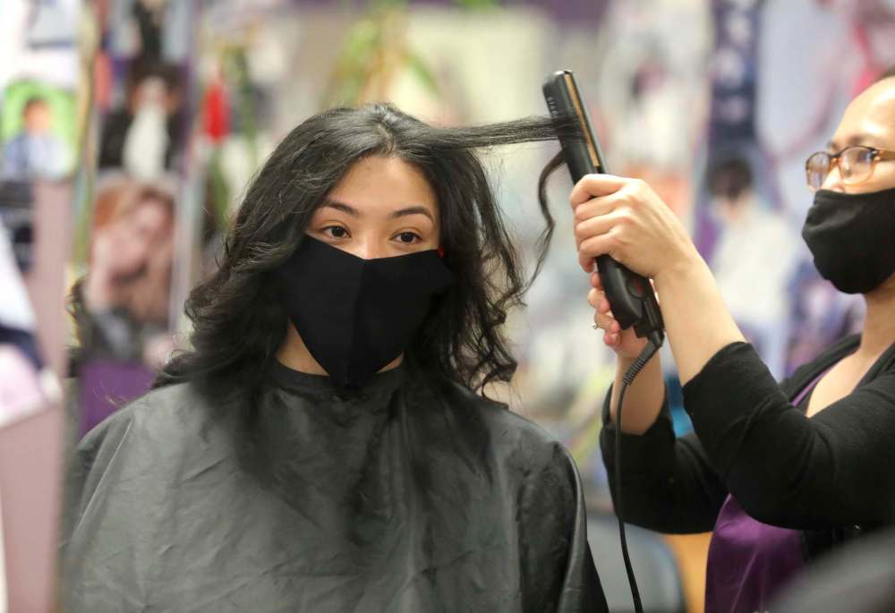 Vanessa Navarro gets her hair styled for her grad photo. (Ruth Bonneville / Winnipeg Free Press)