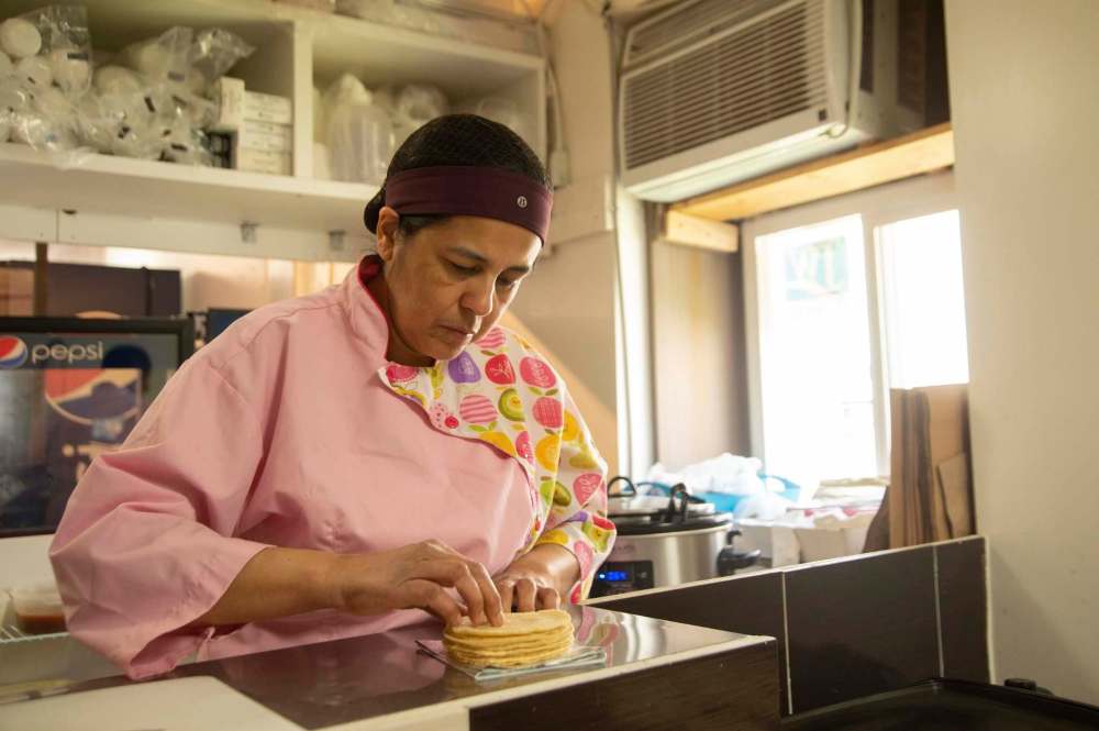 Mike Sudoma / Winnipeg Free Press
BMC Market owner Betty Calteron packages soft tortilla shells to go along with a takeout order.