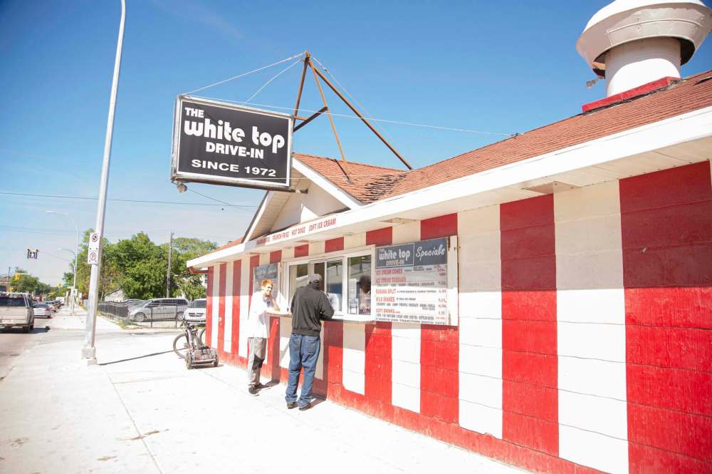 Mike Sudoma / Winnipeg Free Press
Customers wait for their orders outside the white-and-red-striped North End landmark.