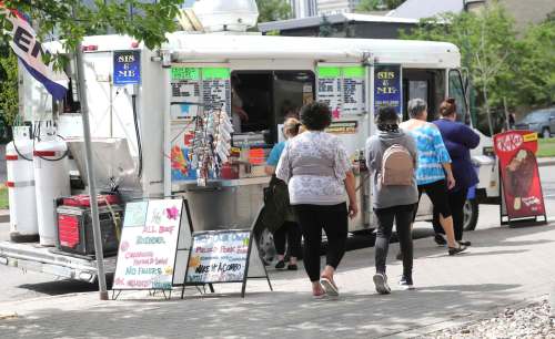 Customers line up to order lunch from Sis & Me food truck on Broadway. (Ruth Bonneville / Winnipeg Free Press)