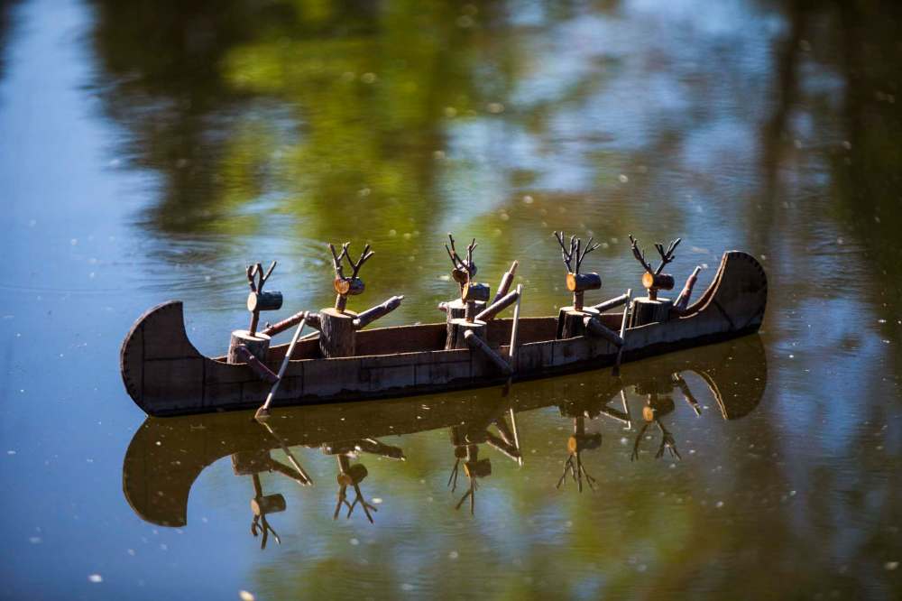 A herd of reindeer take to the water in a canoe. (Mikaela MacKenzie / Winnipeg Free Press)