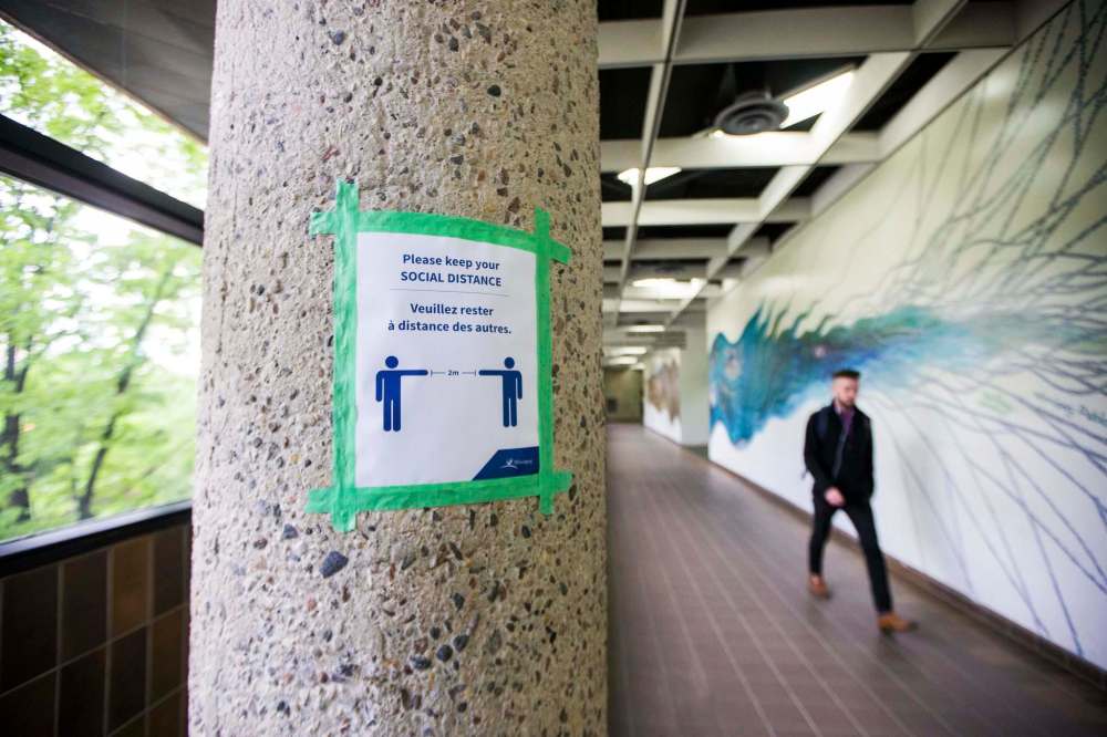 MIKAELA MACKENZIE / WINNIPEG FREE PRESS 
A poster above the Millenium Library reminds people to keep their physical distance from each other.
