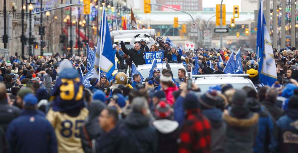 Those were the days: Miller (front left in car) waves to the crowd lined up along Portage Avenue during the team’s Grey Cup championship parade on Nov. 26. (Mike Deal / Winnipeg Free Press files)