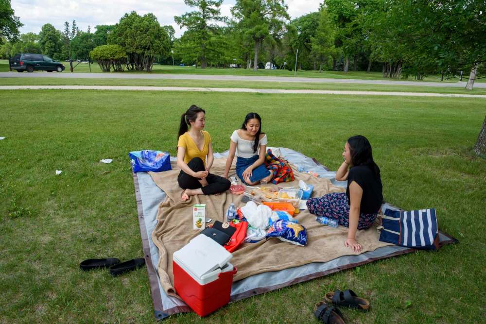 JESSE BOILY / WINNIPEG FREE PRESS
Janet Truong (from left), Loren Panaligan, and Fay Fajardo enjoy the hot weather with a picnic at Assiniboine Park Monday.