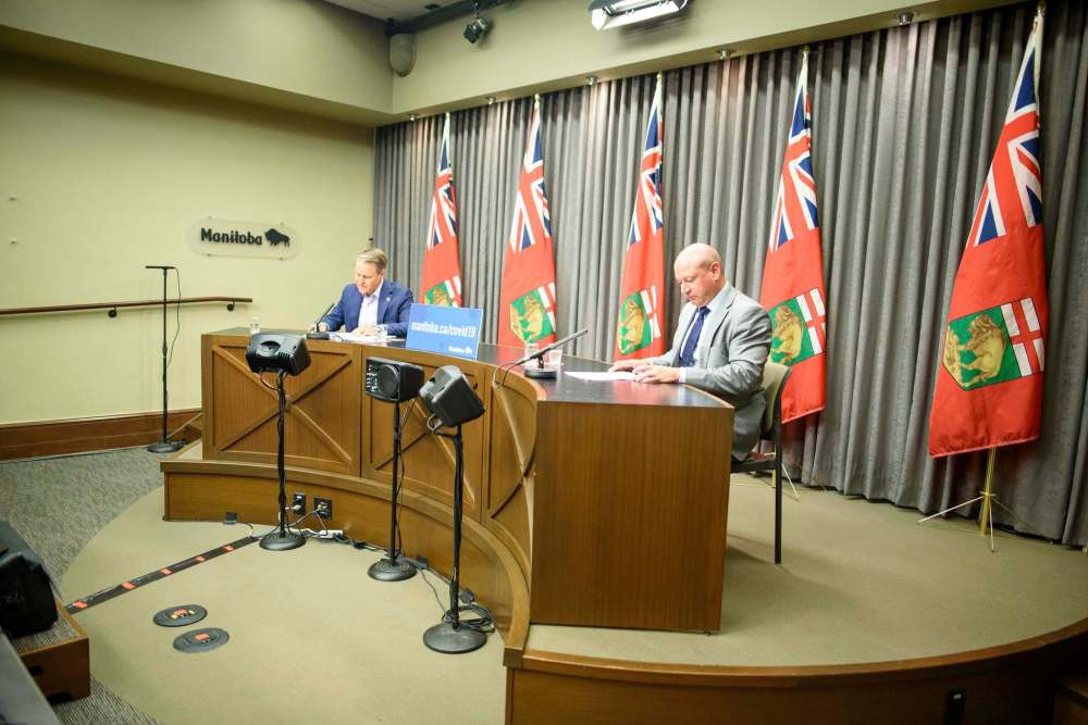 Chief provincial public health officer Dr. Brent Roussin (right) and Health Minister Cameron Friesen explain the reasons behind putting the brakes on some of the Phase 4 reopening plans. (Jesse Boily / Winnipeg Free Press)