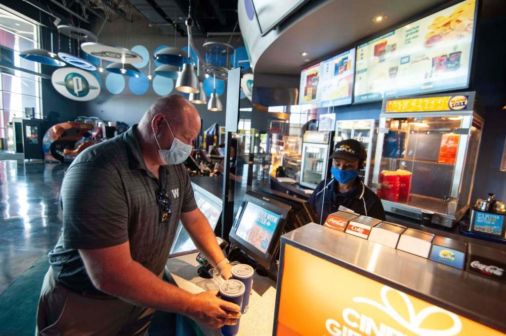 Sean Crawford picks up drinks form the concession stand as he gets ready to enjoy a movie at Scotiabank Theatre for the first time since the Covid-19 lockdown. (Mike Sudoma / Winnipeg Free Press)