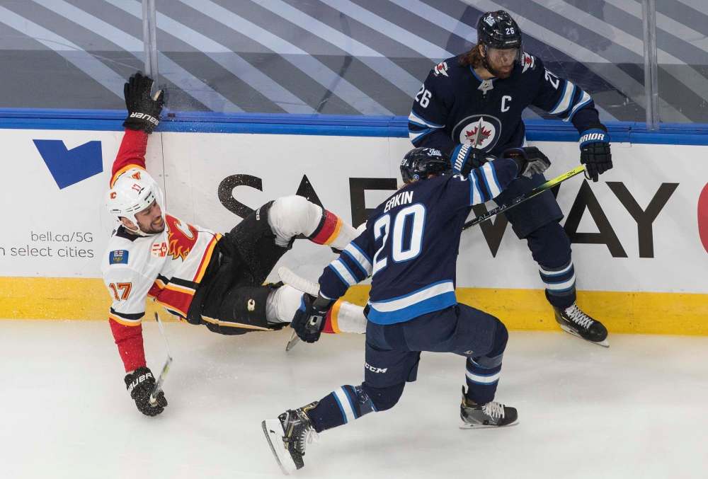 Jason Franson / The Canadian Press
Milan Lucic is checked by Blake Wheeler and Cody Eakin Tuesday.