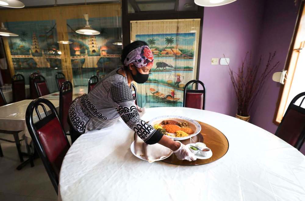 Desta Worku Negatu preparing some Ethiopian favourites in the kitchen, shots of finished dishes in the restaurant (currently only open for pickup and takeout)