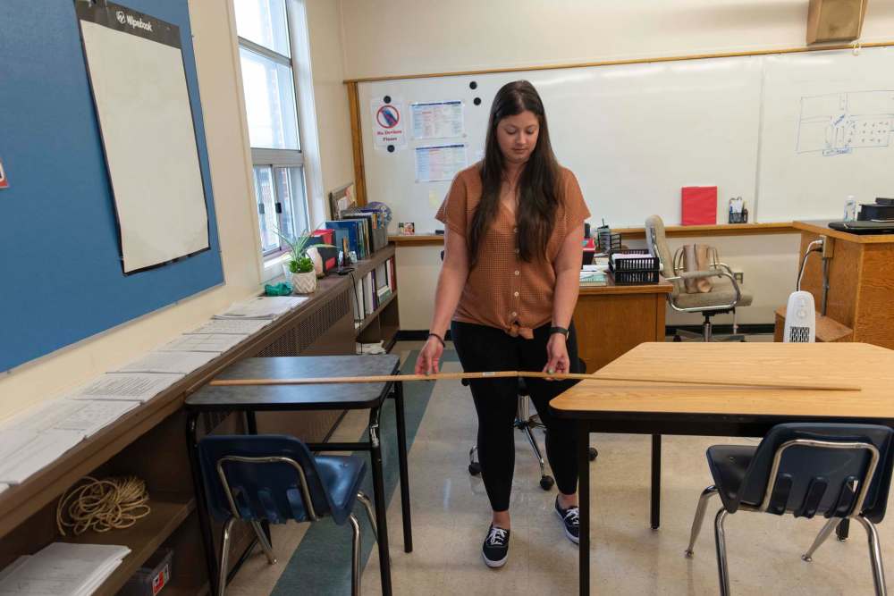 Taylor Marks, a Grade 8 math teacher, shows how she measured out her desks Wednesday in her classroom at Andrew Mynarski V.C. School. (Jesse Boily / Winnipeg Free Press)