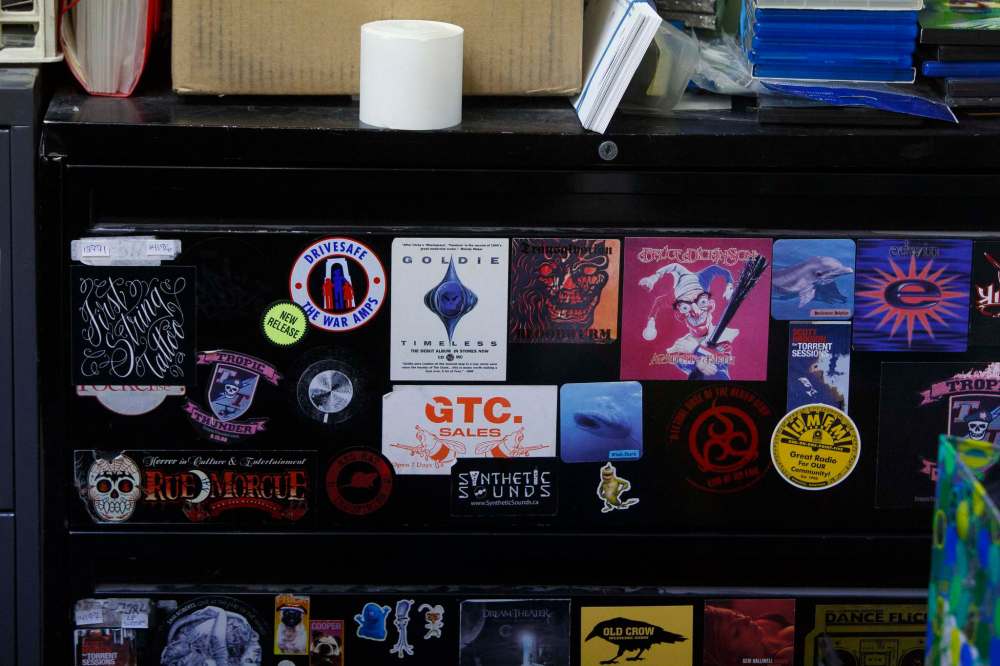 Band stickers cover a filing cabinet near the cash-register. (Mike Deal / Winnipeg Free Press)