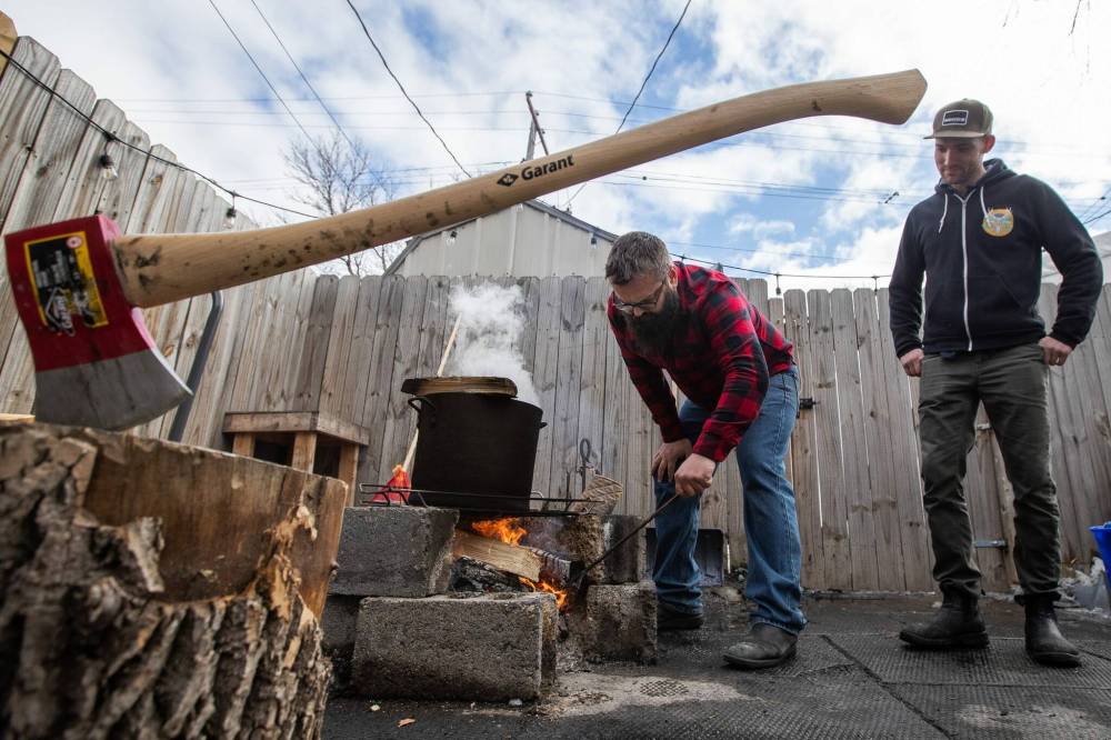 Daniel Crump / Winnipeg Free Press
Jordan Campbell (left) keeps a fire roaring in his backyard to boil down sap into maple syrup.