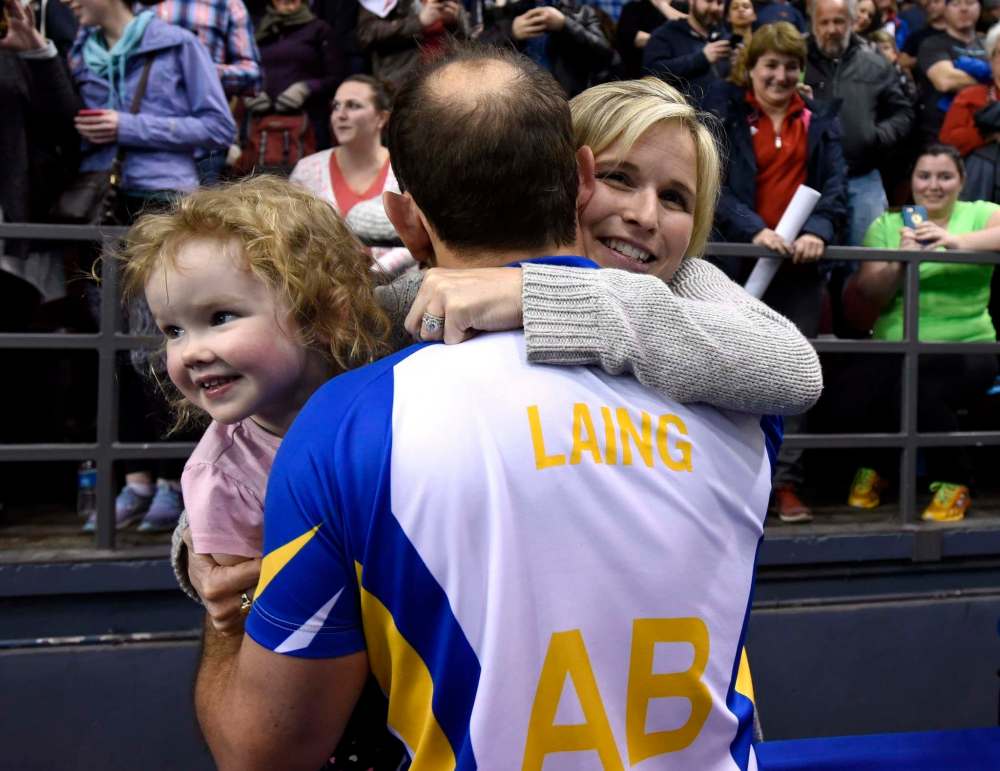 Alberta second Brent Laing, centre, celebrates with his wife Jennifer Jones, a fellow curler, and daughter Isabella Laing after winning in the final against Newfoundland and Labrador at the Tim Hortons Brier curling championship, Sunday March 13, 2016, in Ottawa. THE CANADIAN PRESS/Justin Tang