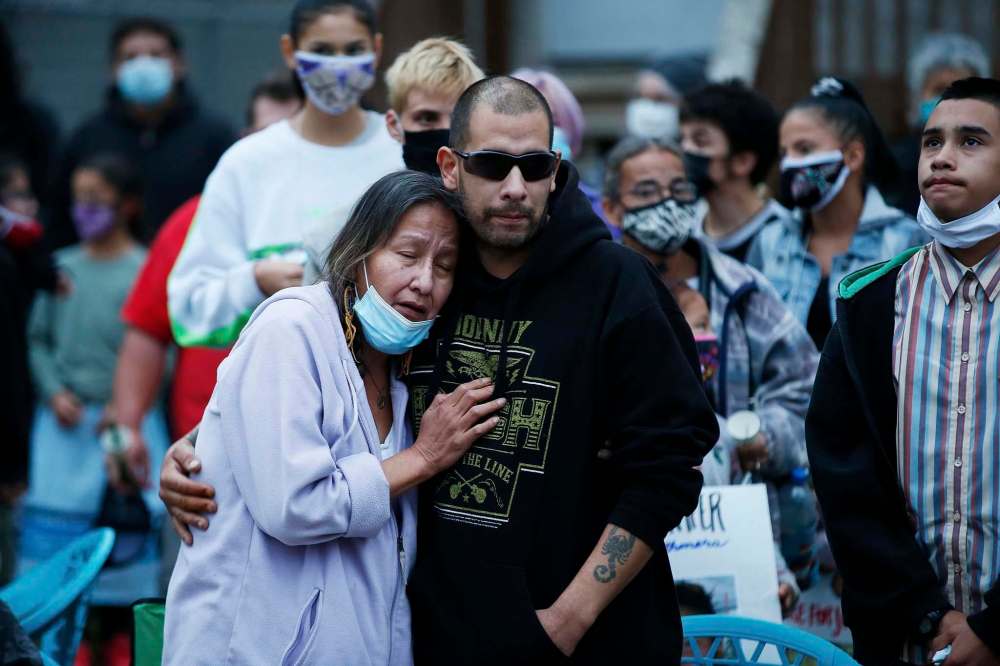 JOHN WOODS / WINNIPEG FREE PRESS
Candy Volk, mother of Jennifer Dethmers, is comforted at a vigil on Boyd Avenue Tuesday evening. Dethmers died when her vehicle was struck by a truck at the intersection of Boyd and Andrews. Its driver was attempting to evade police and has been charged with criminal offences.