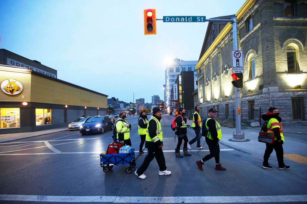 On a recent Monday, a team of seven loaded a blue wagon with sandwiches, water, sharps containers, homemade bannock and Halloween candy and headed into the heart of downtown Winnipeg.