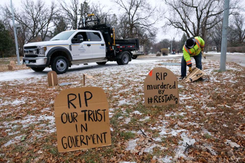 Daniel Crump / Winnipeg Free Press. City crews remove cardboard tombstones and an effigy of Manitoba Premier Brian Pallister dressed as the grim reaper that was set up in front of the Premier’s wellington crescent home. The mock graveyard is a protest over the provincial governments handling of the coronavirus pandemic. October 31, 2020.