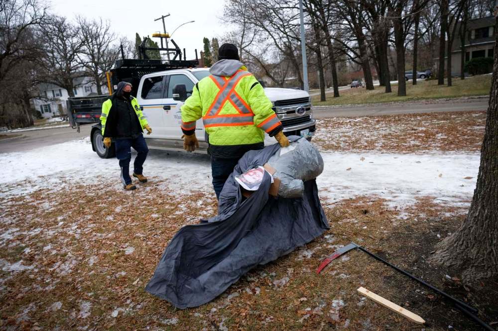 Daniel Crump / Winnipeg Free Press. City crews remove cardboard tombstones and an effigy of Manitoba Premier Brian Pallister dressed as the grim reaper that was set up in front of the Premier’s wellington crescent home. The mock graveyard is a protest over the provincial governments handling of the coronavirus pandemic. October 31, 2020.