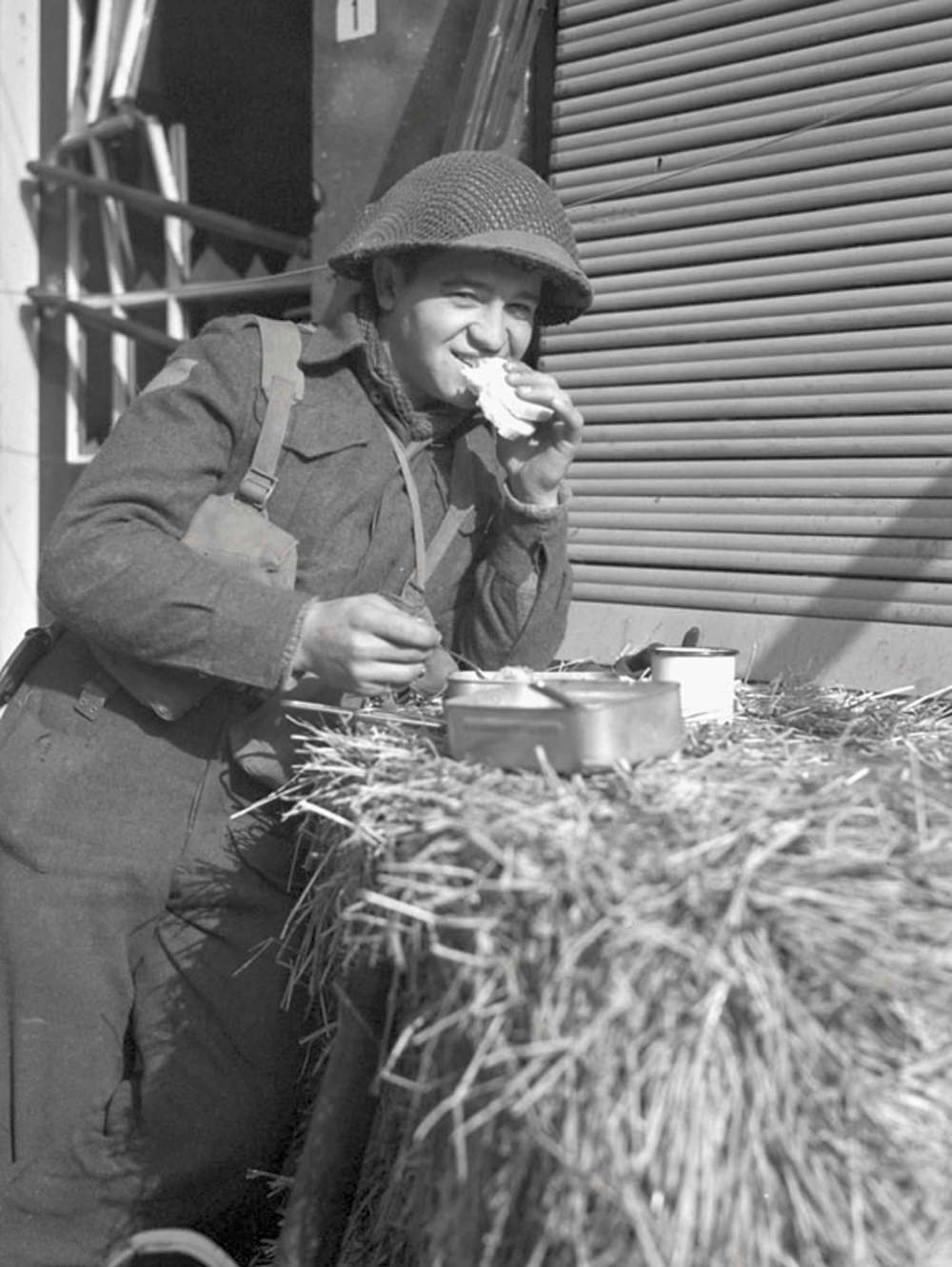 DONALD I. GRANT / LIBRARY AND ARCHIVES OF CANADALance Cpl. W.D. Bunka of the Royal Winnipeg Rifles grabs a bite to eat at Ijzendijke Netherlands, on Oct. 21, 1944.