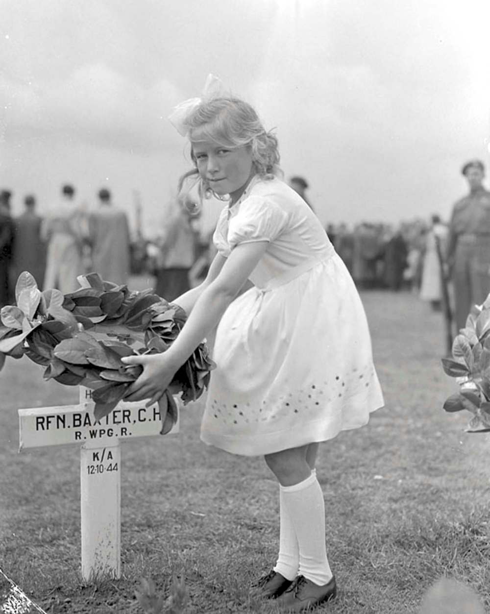R.W. HOLE / LIBRARY AND ARCHIVES CANADAA Dutch girl places flowers on the grave of Cliff Baxter in 1946. Baxter was killed in October 1944 during the liberation of the Netherlands.