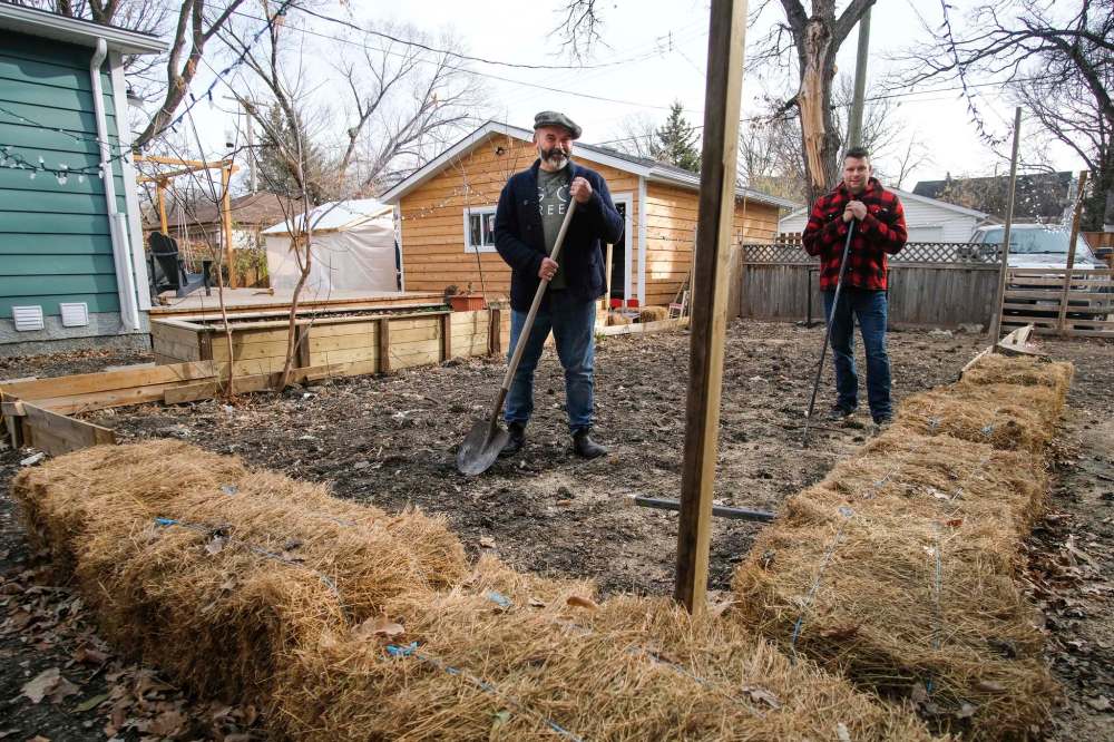 Daniel Crump / Winnipeg Free Press
Stuart Thomas (left) and his Grosvenor Avenue neighbour Greg Maksymowicz prepare the rink that will straddle their property line.